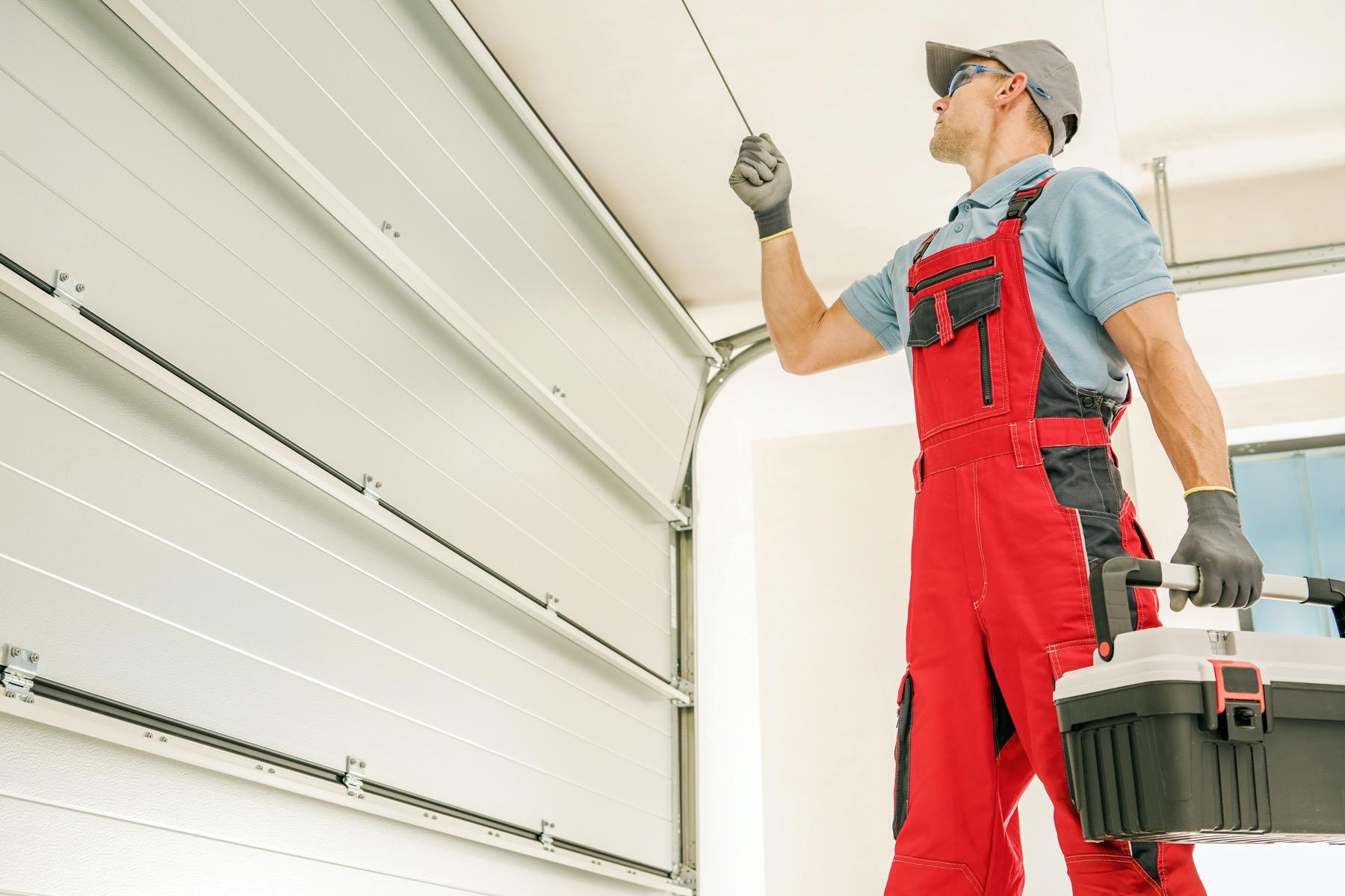 Modern garage door installer at work on a residential home